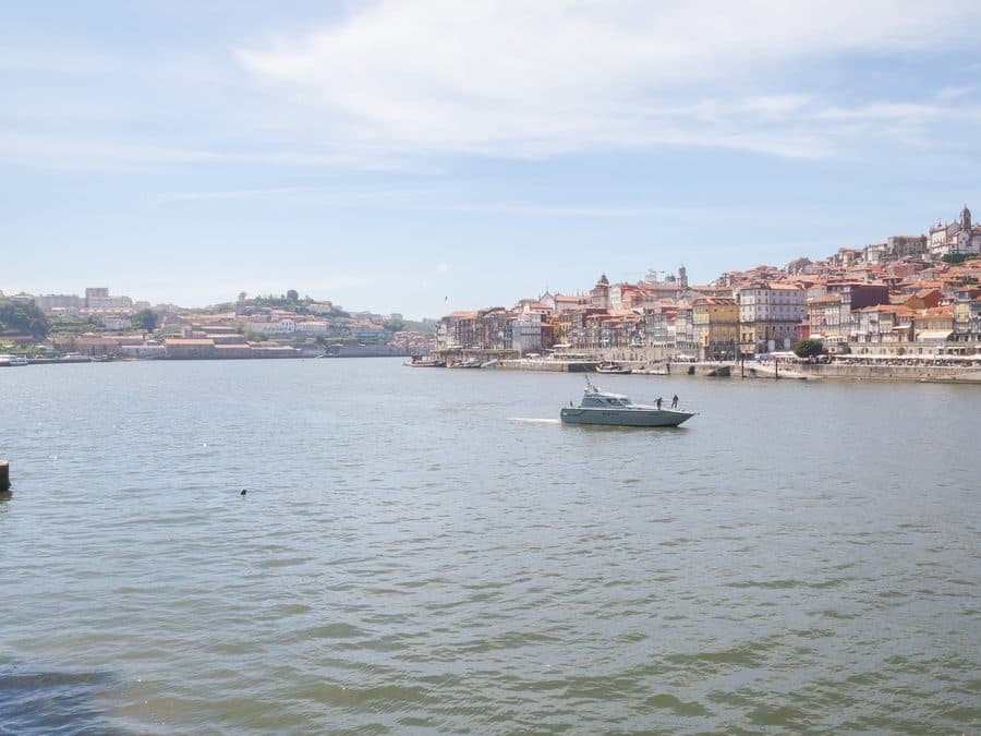 A boat on the Douro river in front of the Ribeira waterfront