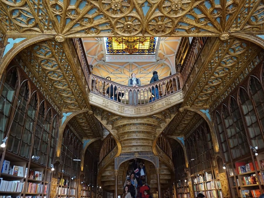The carved staircase and stained glass ceiling of Livraria Lello